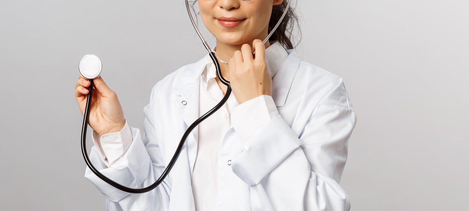 A smiling female doctor holding a stethoscope, showcasing professionalism and care.